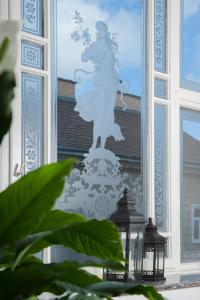 Eine Statue einer Frau, die Blumen im Fenster hält. in der Unterkunft Hotel Kaiserhof Wien in Wien
