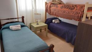 ein Schlafzimmer mit 2 Betten und einem Tisch mit einer Lampe in der Unterkunft Departamento Stanza in Villa Mercedes