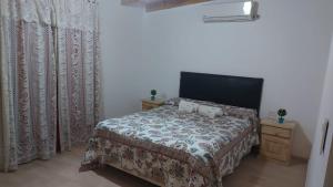 ein Schlafzimmer mit einem Bett in einem Zimmer mit Vorhängen in der Unterkunft Departamento Stanza in Villa Mercedes