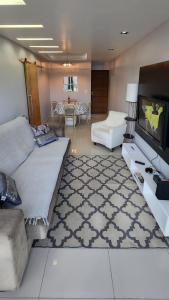 uma sala de estar com um sofá e uma televisão de ecrã plano em Nader Home's - 3 quartos Laranjeiras no Rio de Janeiro