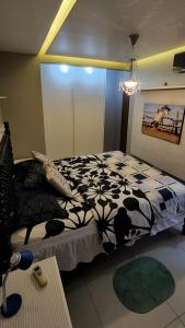 a bedroom with a black and white comforter on a bed at Nader Home's - 3 quartos Laranjeiras in Rio de Janeiro
