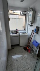 uma pequena cozinha com um fogão e um lavatório em Nader Home's - 3 quartos Laranjeiras no Rio de Janeiro
