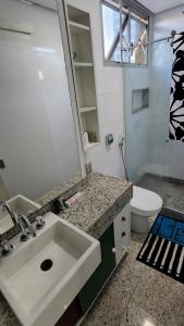 a bathroom with a sink and a toilet and a mirror at Nader Home's - 3 quartos Laranjeiras in Rio de Janeiro