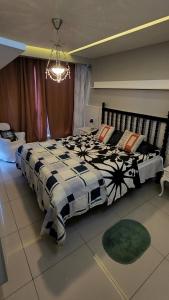 a bedroom with a large bed with a black and white comforter at Nader Home's - 3 quartos Laranjeiras in Rio de Janeiro