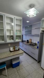 duża kuchnia z białymi szafkami i niebieskimi blatami w obiekcie Nader Home's - 3 quartos Laranjeiras w mieście Rio de Janeiro