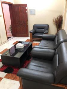 ein Wohnzimmer mit einem Ledersofa und einem Tisch in der Unterkunft بيت المصيف in Ta'if