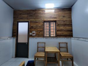 a room with two chairs and a table and a door at Đắk G'lung Bungalow in Bu Yal (1)