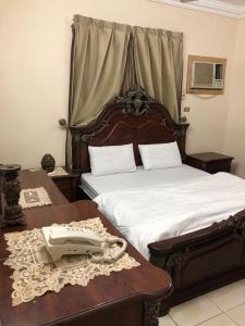a bedroom with two beds and a phone on a table at بيت المصيف in Taif