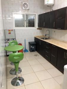 uma cozinha com um banco verde e um lavatório em بيت المصيف em Taif
