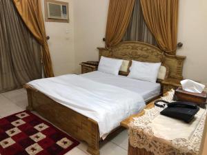 Schlafzimmer mit einem Bett und einem Telefon auf einem Tisch in der Unterkunft بيت المصيف in Ta'if