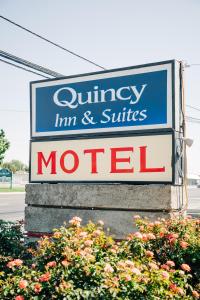 ein Schild für ein Pflegegasthaus und ein Motel für Suiten in der Unterkunft Quincy INN and Suites in Quincy