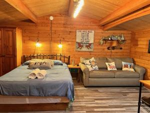 a bedroom with a bed and a couch in a cabin at Lakeshore Lily Pad in Hayward