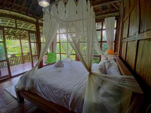 a bedroom with a bed with mosquito netting at Bali Jungle Camping by Amerta Experience in Tabanan