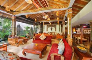 un soggiorno con divano rosso e tavolo di Rama Garden Hotel Bali a Legian