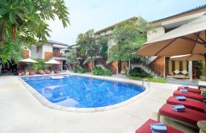 basen z krzesłami i budynek w obiekcie Rama Garden Hotel Bali w mieście Legian