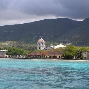 an island with a church in the middle of the water at Azulea Lodging House Oslob in Oslob