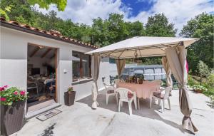 a patio with a table and an umbrella at 2 Bedroom Cozy Home In Kostrcani in Kostrčani