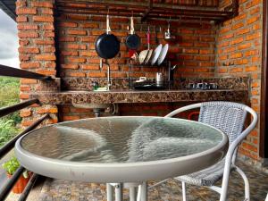a table and chairs in a kitchen with a brick wall at Vila NJD in Bogor