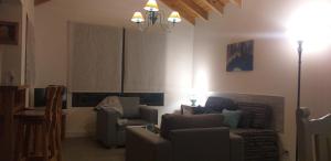 - un salon avec deux chaises et un canapé dans l'établissement Departamento "Avanti", à San Martín de los Andes