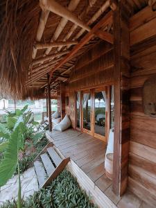 Sumba Beach House في وايكابوباك: شرفة خشبية منزل به سقف
