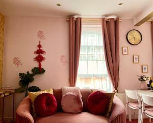 uma sala de estar com um sofá e um relógio na parede em London Chinatown Apartments em Londres