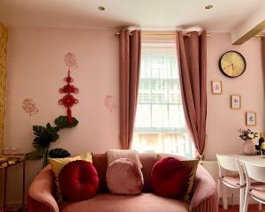 London Chinatown Apartments في لندن: غرفة معيشة مع أريكة وساعة على الحائط