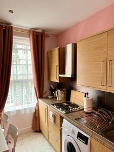 a kitchen with a stove top oven next to a window at London Chinatown Apartments in London