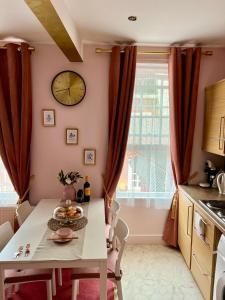 a kitchen with a table and a clock on the wall at London Chinatown Apartments in London