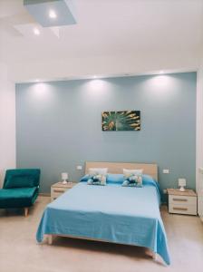 1 dormitorio con 1 cama azul y 1 silla verde en Casa Vin, en Massafra