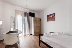 a bedroom with a bed and a desk and a window at Super View Apartments in Heraklio Town