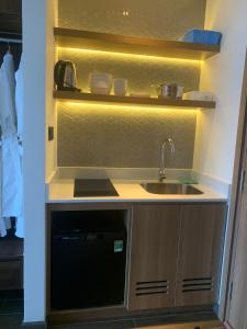 a small kitchen with a sink and a microwave at Win Condotel Apec Phú Yên in Tuy Hoa