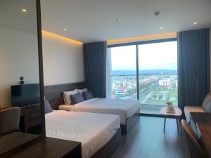 una camera d'albergo con due letti e una grande finestra di Win Condotel Apec Phú Yên a Tuy Hoa