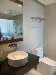 a bathroom with a sink and a toilet and a mirror at Win Condotel Apec Phú Yên in Tuy Hoa