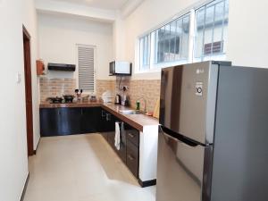 a kitchen with a refrigerator and a sink at Villa 58 Unawatuna in Unawatuna