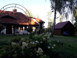 a house with a garden in front of it at Królowa Luiza i Wiking in Stare Jabłonki