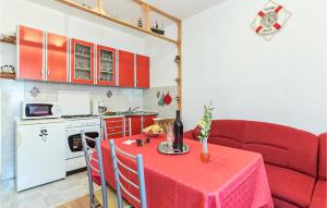 uma sala de estar com uma mesa e um sofá vermelho em 2 Bedroom Lovely Apartment In Labin em Labin