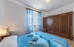 um quarto com uma cama azul e um armário de madeira em 2 Bedroom Lovely Apartment In Labin em Labin