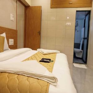 a hotel room with two beds and a bathroom at Hotel New Sarah Inn, Andheri West in Mumbai