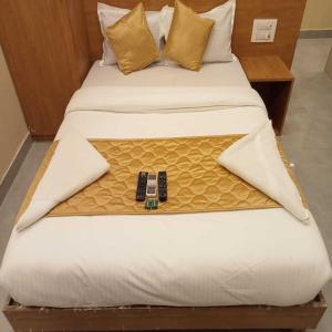 a bed with a cell phone on top of it at Hotel New Sarah Inn, Andheri West in Mumbai