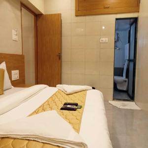 a hotel room with two beds and a bathroom at Hotel New Sarah Inn, Andheri West in Mumbai