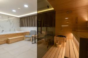 a bathroom with a tub and a table and a chair at President Apartman Spa in Vračar (historical) +35 photos