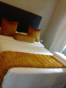 a bed with orange and white sheets and pillows at Recoupe in East London