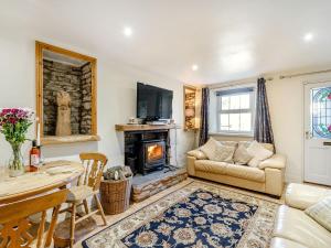 a living room with a couch and a fireplace at Kidsty Cottage in Penrith