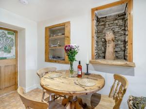 a dining room with a wooden table and chairs at Kidsty Cottage in Penrith