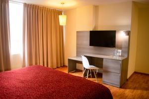 Cette chambre d'hôtel dispose d'un bureau et d'une télévision. dans l'établissement Hotel Del Angel Reforma, à Mexico