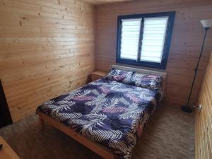 een slaapkamer met een bed in een houten hut bij Cabana DEMI in Gheorgheni