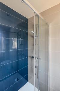 a bathroom with a shower with a glass door at Le Cancaven - Côté Mer - Très belle vue mer in Saint-Benoît-des-Ondes