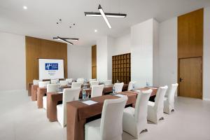 une salle de conférence avec des tables en bois et des chaises blanches dans l'établissement Holiday Inn Express Chongli, an IHG Hotel, à Zhangjiakou