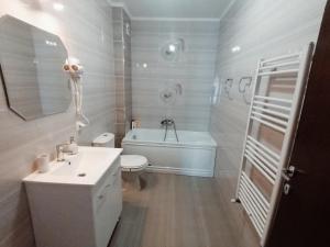 y baño con lavabo, aseo y bañera. en AMA Apartament cu terasă 50 mp & parcare en Brasov