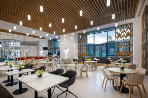 - une salle à manger avec des tables, des chaises et des fenêtres dans l'établissement Holiday Inn Express Chongli, an IHG Hotel, à Zhangjiakou